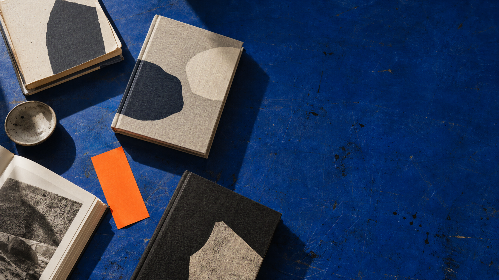 Margin Press books arranged on an ultramarine printing table